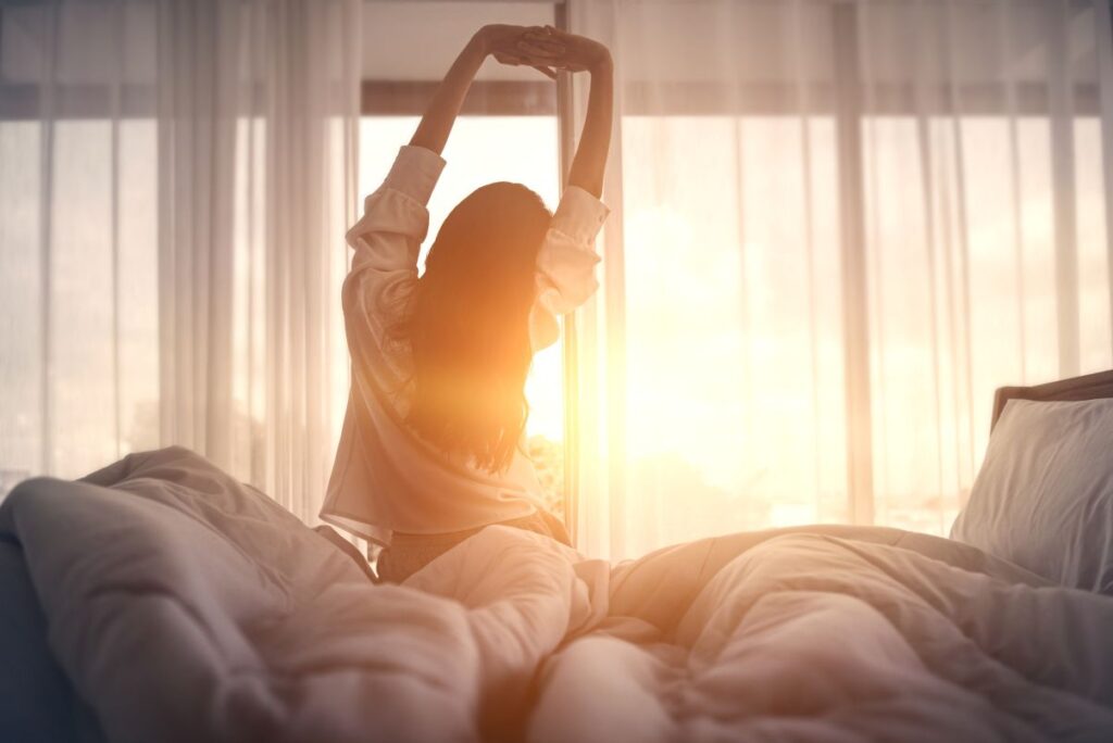 A woman stretching in bed.